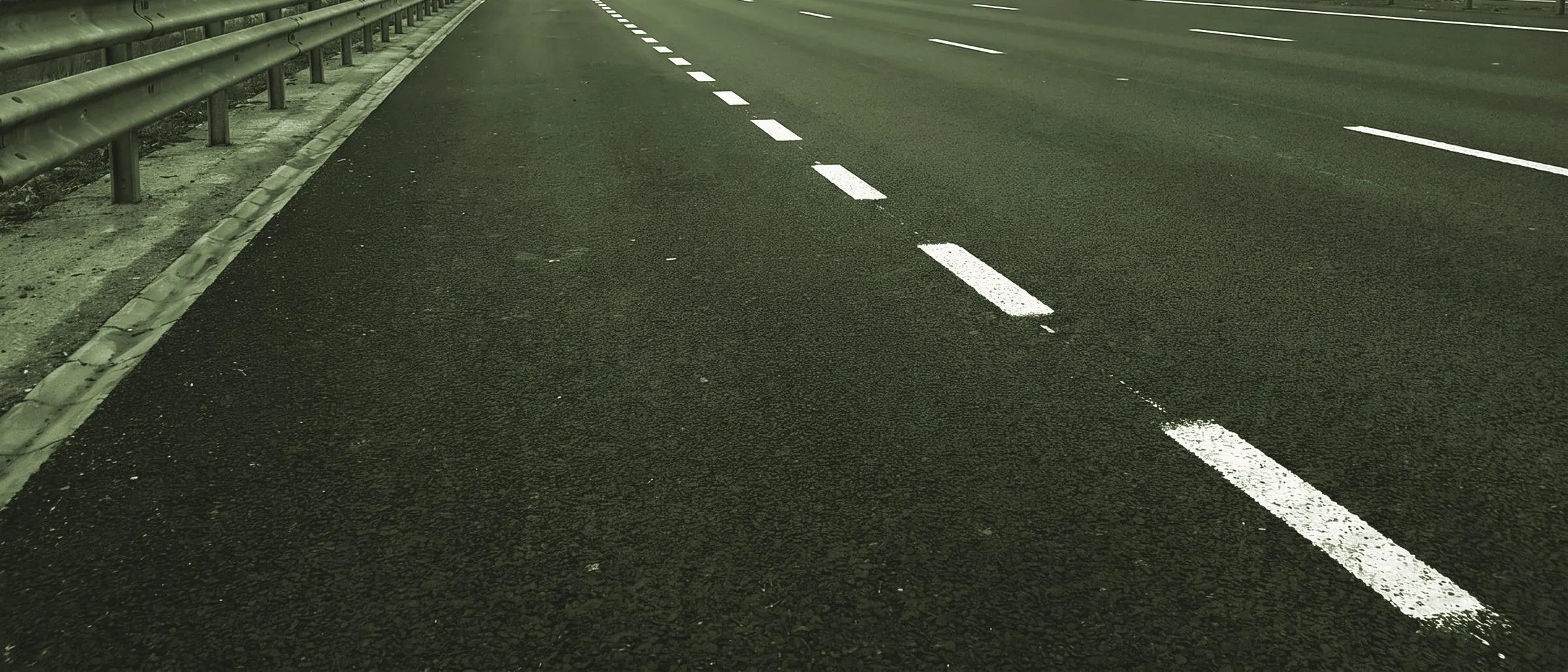 Asphaltdecke mit unterbrochener Fahrbahnmarkierung